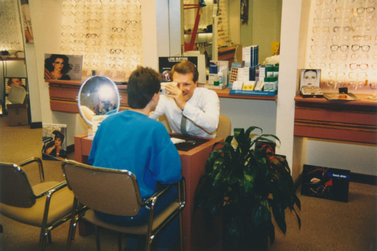 Optician Daniel Klein serving a client at his optical store in the mid to late 1980s.