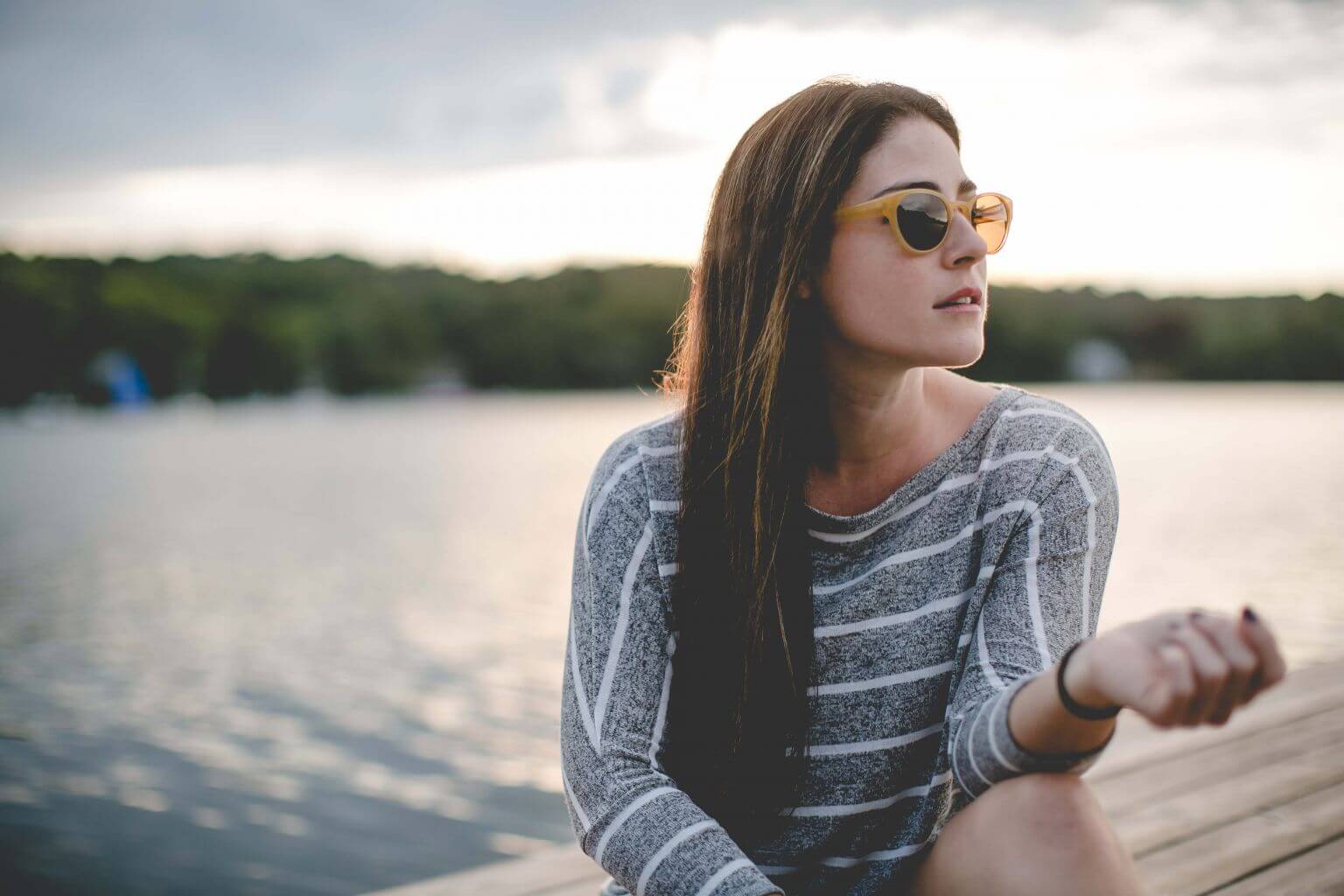 Woman wearing Klein 1991 Fran plastic sunglass frames in butterscotch.