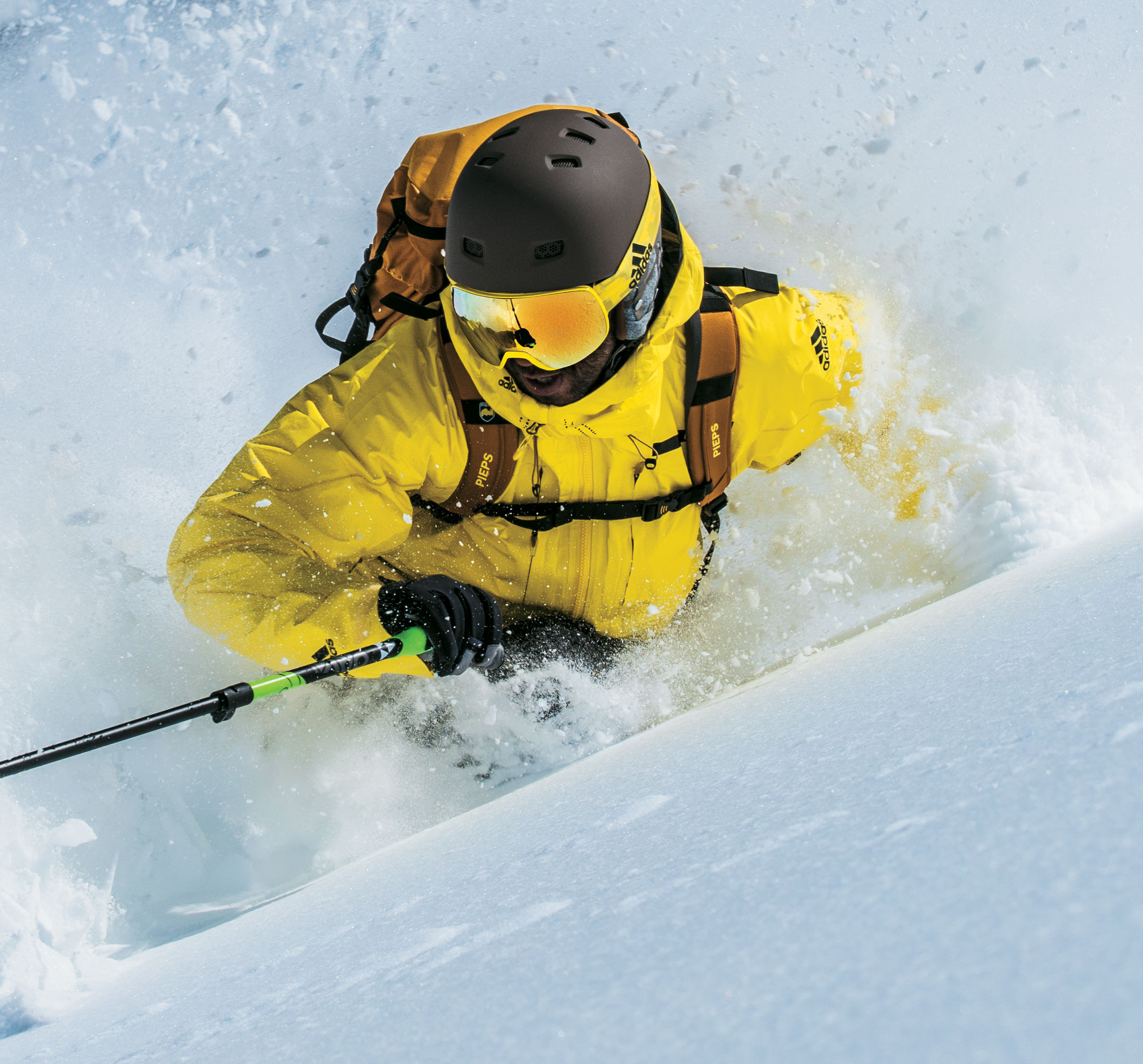Man skiing wearing adidas Sport Eyewear Progressor S ski goggles in shiny bright yellow with gold mirror lens.