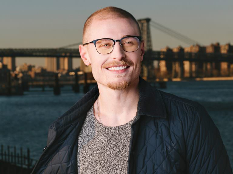 Man wearing O&X NEW YORK Chadwick stainless steel eyeglass frames in Matte Blue.
