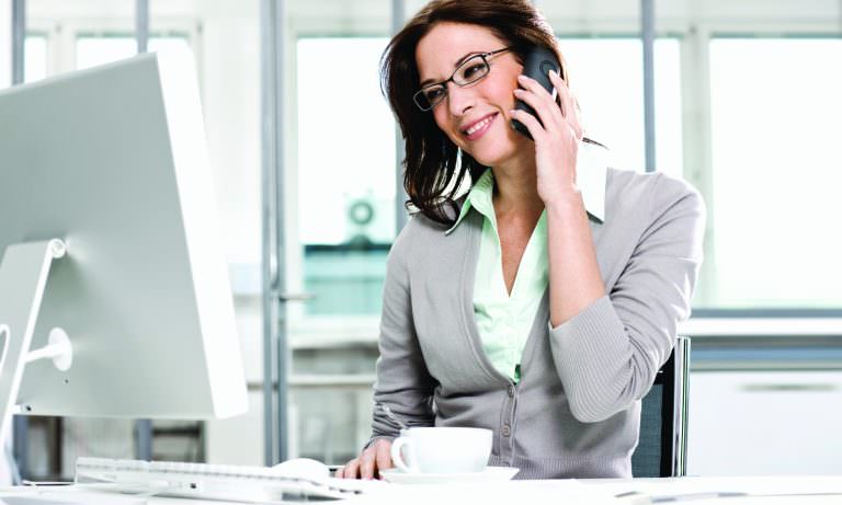 Woman in office using ZEISS i.Scription lenses for computer work.