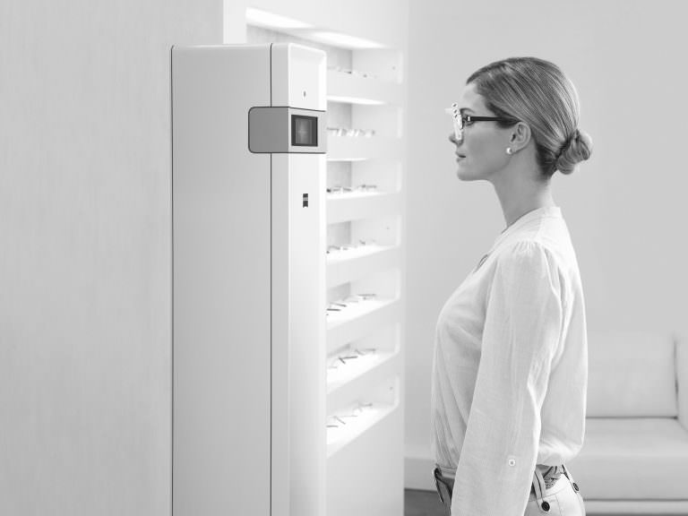 A female patient wearing a new frame is digitally measured by i.Terminal 2.