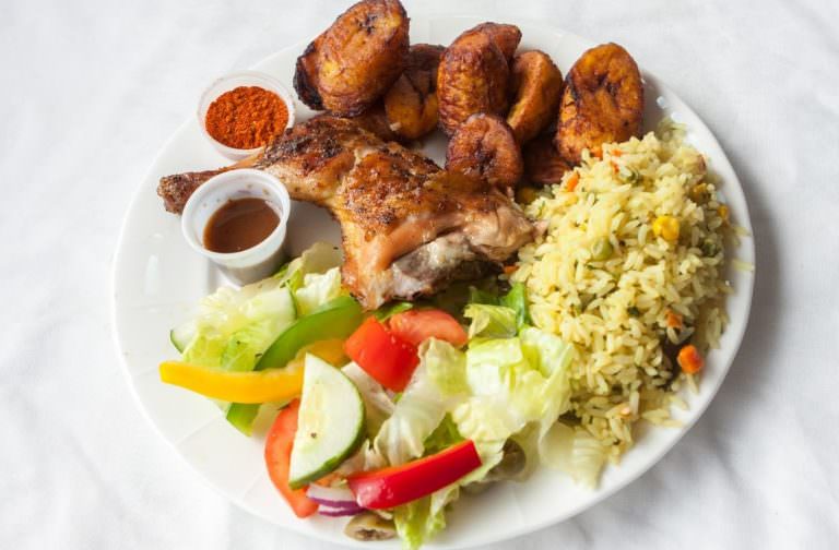 Signature Charcoal Grilled Chicken Platter by Pili Pili Grilled Chicken including seasoned rice, plantain, and garden salad.